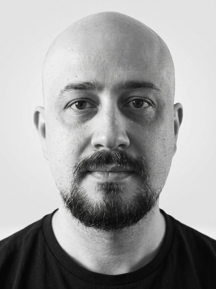 Black and white portrait of Ali Ali looking straight at the camera